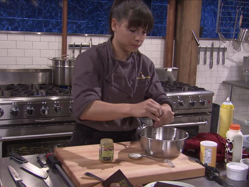 The writer on "Chopped" putting bars of chocolate into a deep saucepan