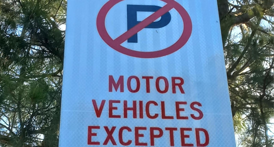 The parking sign can be seen with a red circle, with a diagonal line crossing out a black P, with the words 'Motor Vehicles Expected' underneath. 