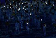 Performers carry lights during the closing ceremony for the 2014 Sochi Winter Olympics, February 23, 2014. REUTERS/Issei Kato (RUSSIA - Tags: OLYMPICS SPORT)