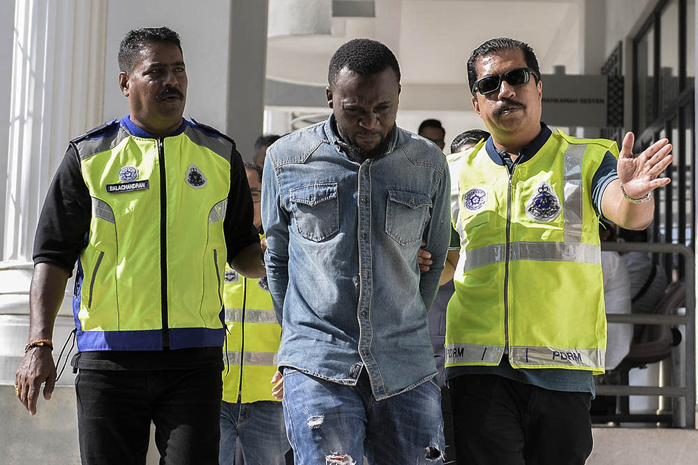 Alowonlw Oluwajuwon Gilbert, the suspect in the murder of Serdang Hospital chief nurse Siti Kharina Mohd Kamarudin, is led to the Magistrate Court in Sepang May 27, 2019. — Picture by Miera Zulyana