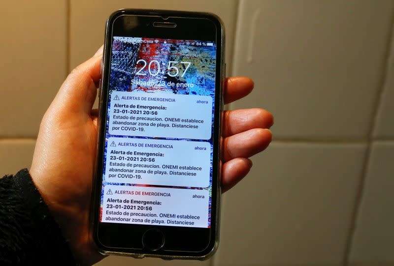 A cell phone is seen with a tsunami warning message sent by mistake by the national emergency office, in Vina del Mar