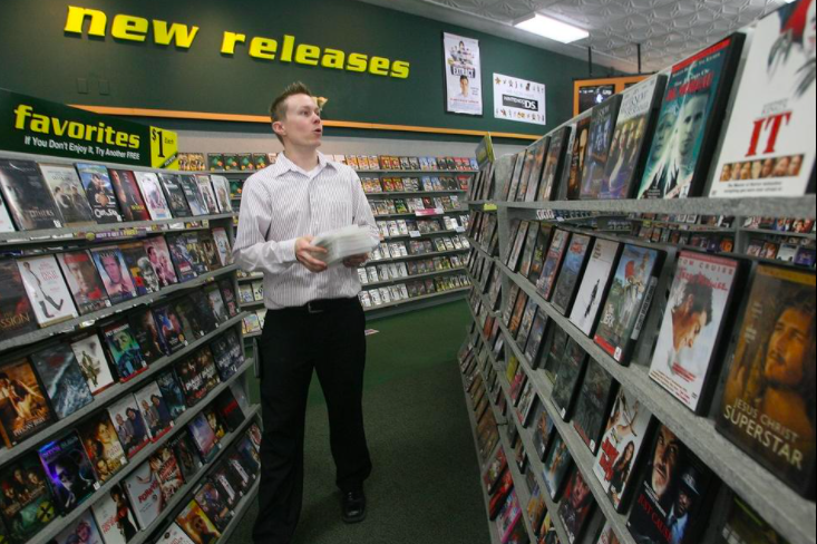 A store manager at Family Video's 1614 S. MacArthur Blvd. location, places DVDs back on the store's shelves in 2014.