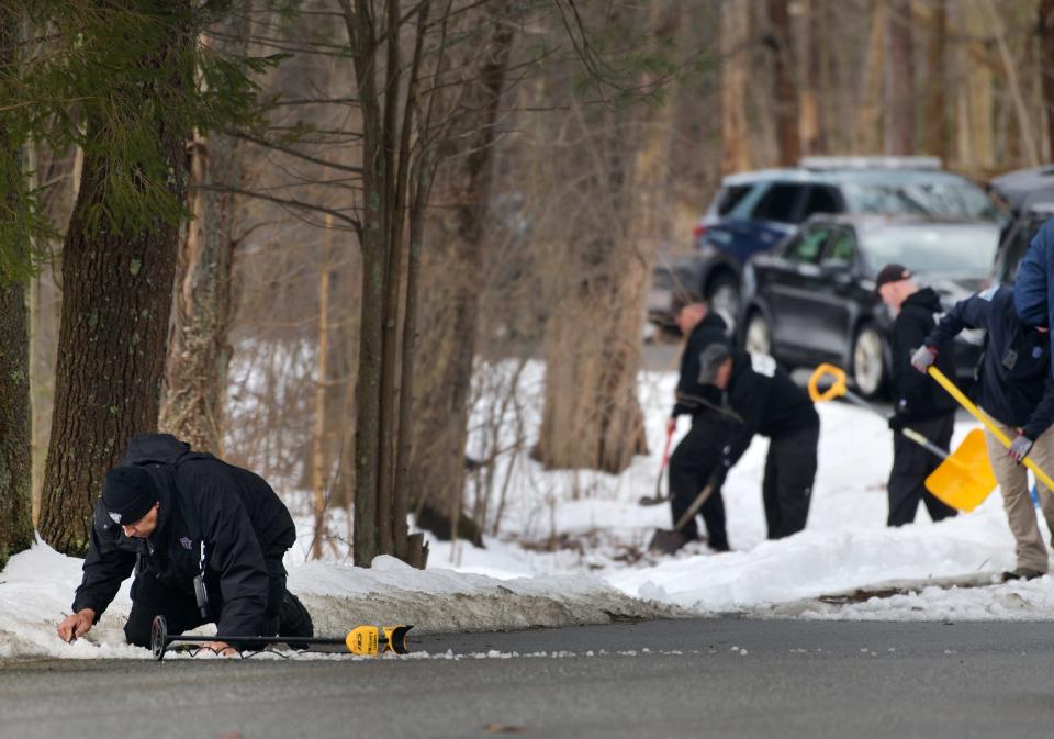 State police use shovels, rakes and metal detectors Sunday along Asnebumpskit Road in Paxton, where a body was found Saturday.