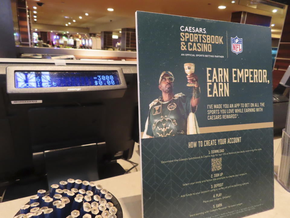 A sign bearing an advertisement for Caesars Entertainment's sports betting operation is displayed near a sports betting terminal in the sports betting lounge at the Tropicana casino in Atlantic City, N.J., May 12, 2022. Caesars is one of the most frequent advertisers of sports betting in the United States. Most of the nation's major professional sports leagues, plus the FOX media company are creating an alliance to ensure that sports betting advertising is done responsibly and does not target minors, it was announced Wednesday, April 19, 2023. (AP Photo/Wayne Parry)