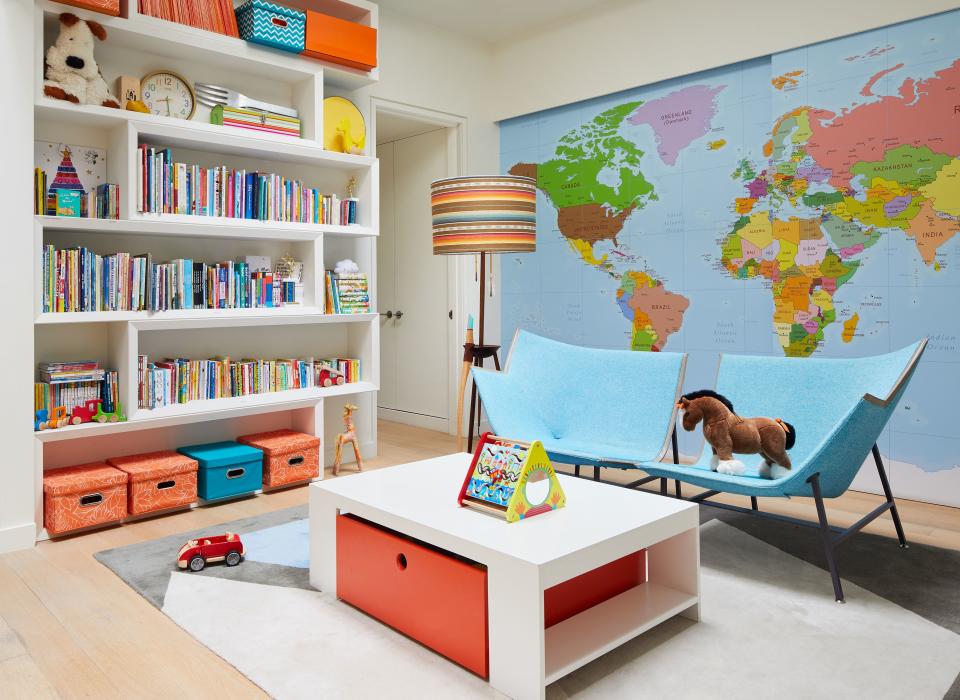 A globally inspired playroom for an international family. Verhoeven wants her kids to be aware of the rest of the world—and realize New York is just a little blip—so they worked hard to find a decal that would cover the sliding doors in the colorful space dotted with cheerful convertible blue chairs by Dutch designer Maarten Baas, a limited edition she found at Salone del Mobile.