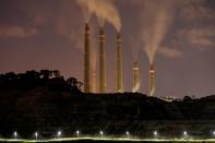 FILE PHOTO: Smoke and steam billows from the coal-fired power plant owned by Indonesia Power, next to an area for Java 9 and 10 Coal-Fired Steam Power Plant Project in Suralaya