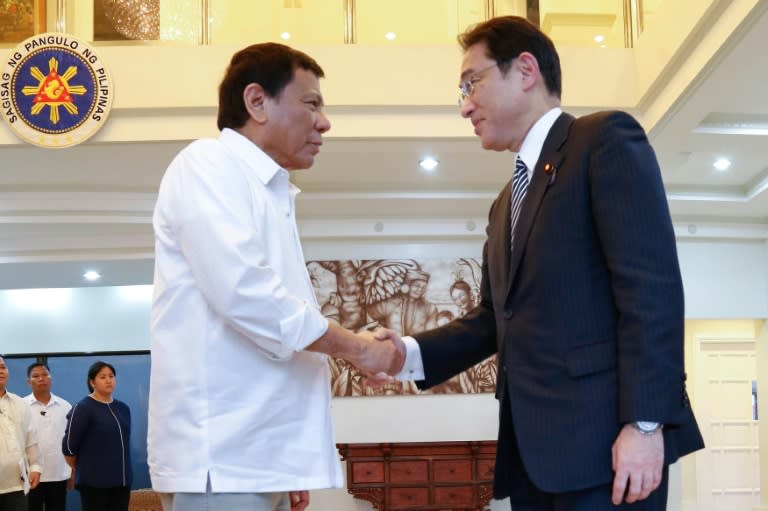 Philippine President Rodrigo Duterte (L) greets Japan's Foreign Minister Fumio Kishida (R) in Davao, on the southern island of Mindanao on August 11, 2016