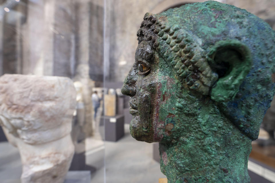 A 480 BC sculpture head found in Athens, Greece, and made of bronze, bone, and stone, is on display at the exhibition 'Between us and the ancients. The instant and eternity' in Rome's Diocletian Baths, Wednesday, May 3, 2023. The exhibition will open to the public from May 4 through July 30, 2023.(AP Photo/Domenico Stinellis)