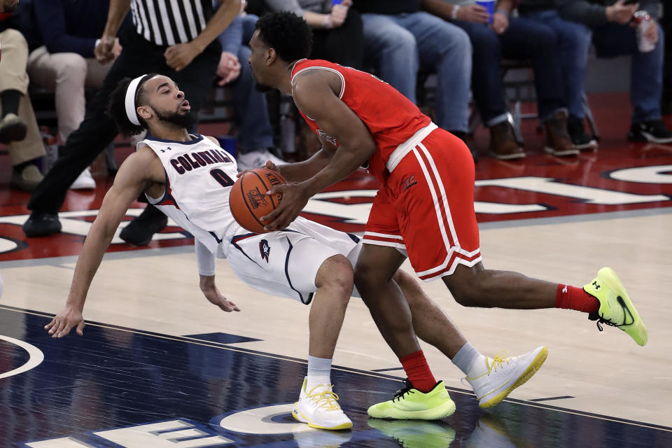 St. Francis' Keith Braxton, right, fouls Robert Morris' Josh Williams (0) during the first half of an NCAA college basketball game for the Northeastern Conference men's tournament championship in Pittsburgh, Tuesday, March 10, 2020. (AP Photo/Gene J. Puskar)