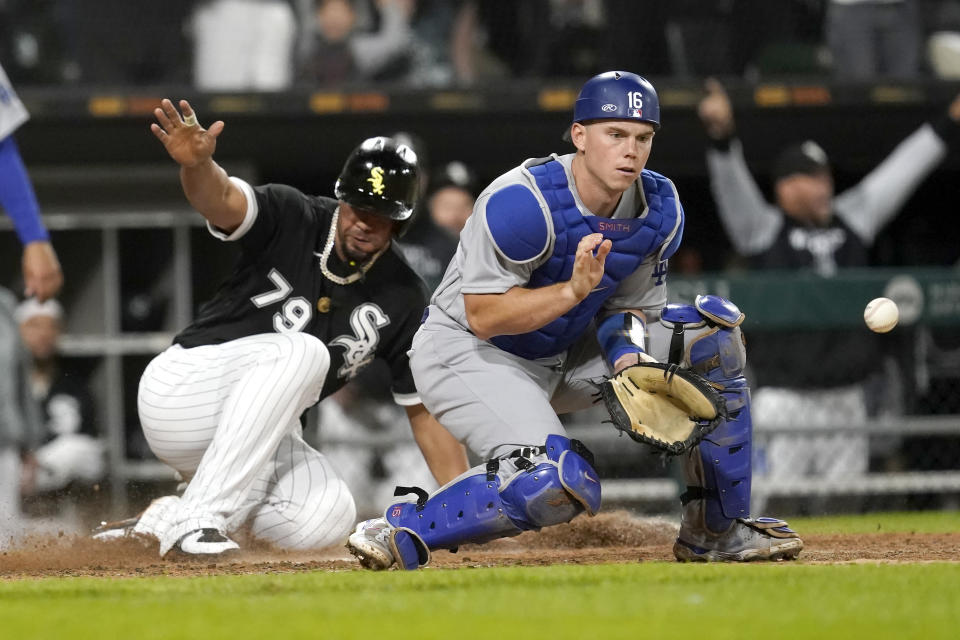 Chicago White Sox's Jose Abreu (79) scores as Los Angeles Dodgers catcher Will Smith waits for the throw after a pinch-hit, two-run double by AJ Pollock during the sixth inning of a baseball game Tuesday, June 7, 2022, in Chicago. (AP Photo/Charles Rex Arbogast)
