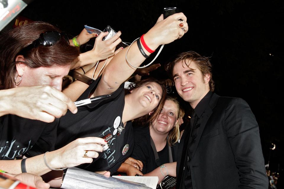Robert Pattinson taking pictures with Twilight fans