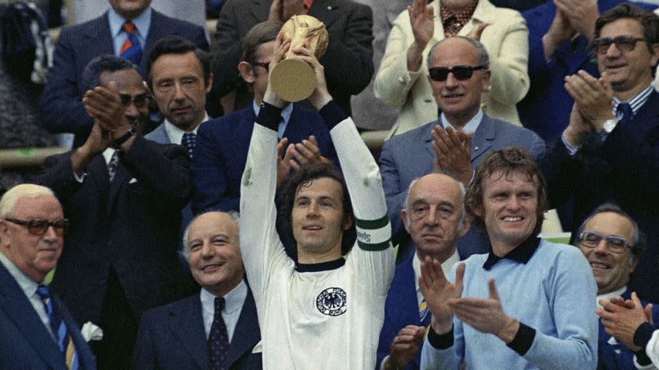 Beckenbauer raises the World Cup trophy in 1974. - AP