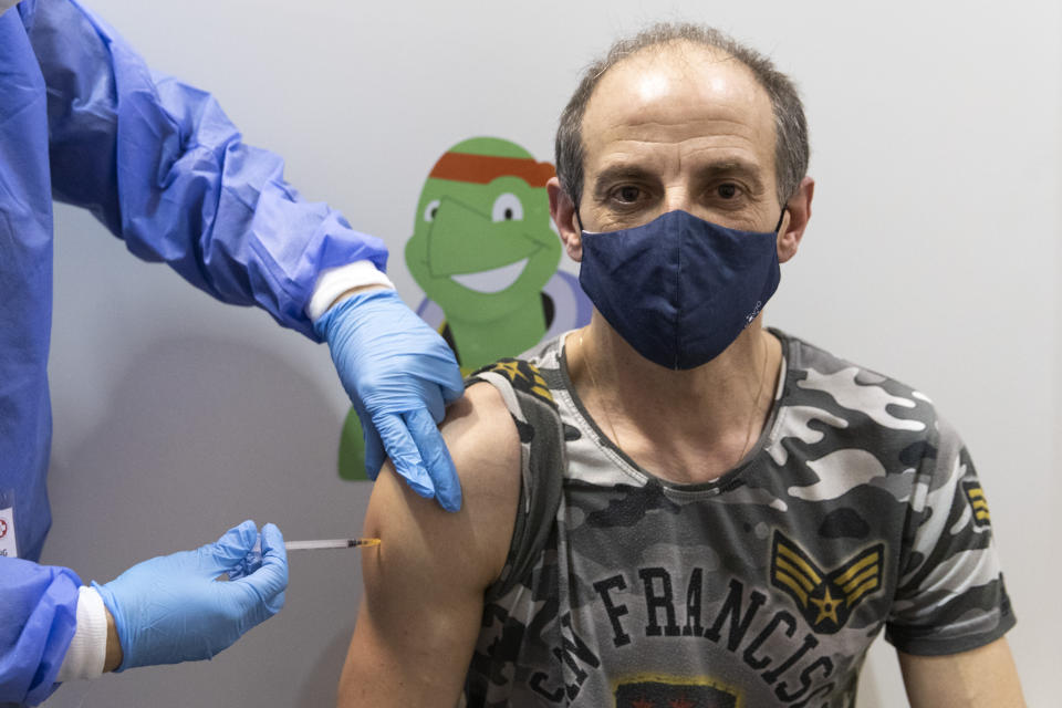 A person gets vaccinated against the COVID-19 virus as the compulsory COVID-19 vaccination starts in Vienna, Austria, Friday, Feb. 4, 2022. (AP Photo/Lisa Leutner)