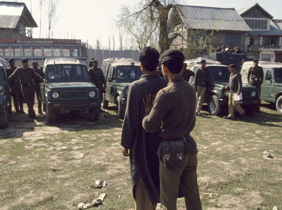 An Indian Border Security Force soldier shows a suspected militant to people in a line of parked military vehicles, Srinagar, India, on July 28, 1994. | Robert Nickelsberg—Getty Images