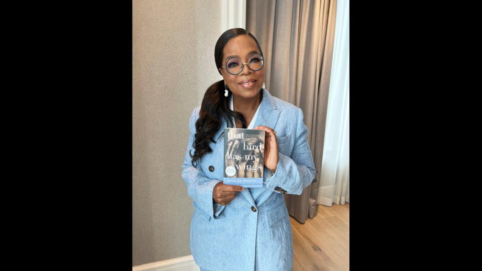 Winfrey poses with Masters's book. 