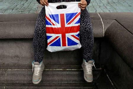 FILE PHOTO: A woman holds a Union Flag shopping bag in London, Britain April 23, 2016. REUTERS/Kevin Coombs/File Photo