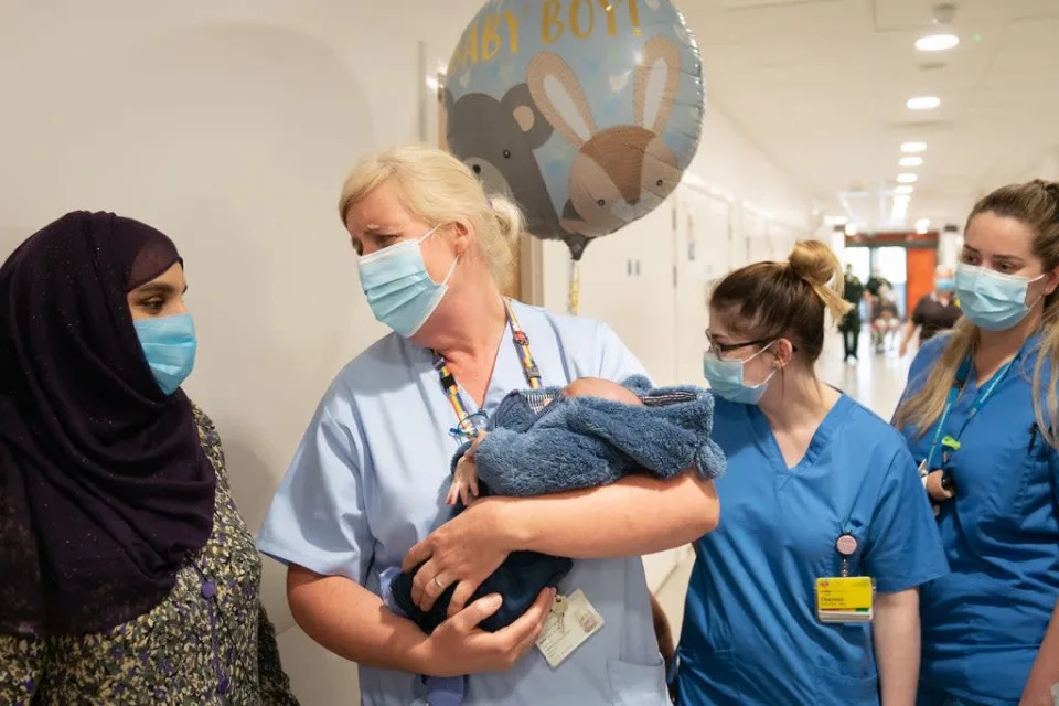 La enfermera de urgencias Helen Flanagan carga al beb&#xe9; de dos semanas, Ibrahim Mohammed, en Northwick Park Hospital en Harrow (PA)