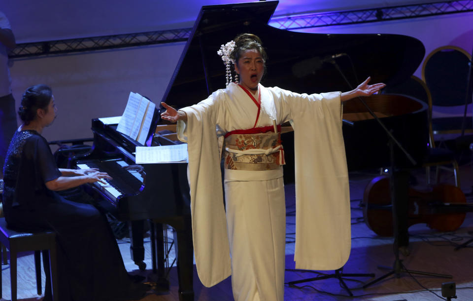 Japanese pianist Kaoru Imahigashi plays the piano while opera singer Fujiko Hirai, right, perform during a concert to mark the debut of Gaza's only grand piano after it was rescued from conflict, at a theater nestled in the Palestinian Red Crescent Society's building in Gaza City, Sunday, Nov. 25, 2018. The only grand piano in the Gaza Strip is debuting to the public for the first time in over a decade after its restoration. (AP Photo/Adel Hana)