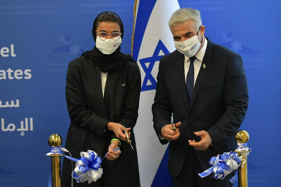 In this photo made available by the Israeli Government Press Office, UAE Minister of Culture and Knowledge Development, Noura Al Kaabi, left, cuts a ribbon with Israeli Foreign Minister Yair Lapid during the inauguration of the Israeli Embassy in Abu Dhabi, United Arab Emirates, Tuesday, June 29, 2021. Israel’s new foreign minister is in the UAE on the first high-level trip by an Israeli official to the Gulf Arab state since the two countries normalized relations last year. (Shlomi Amsalem/Government Press Office via AP)