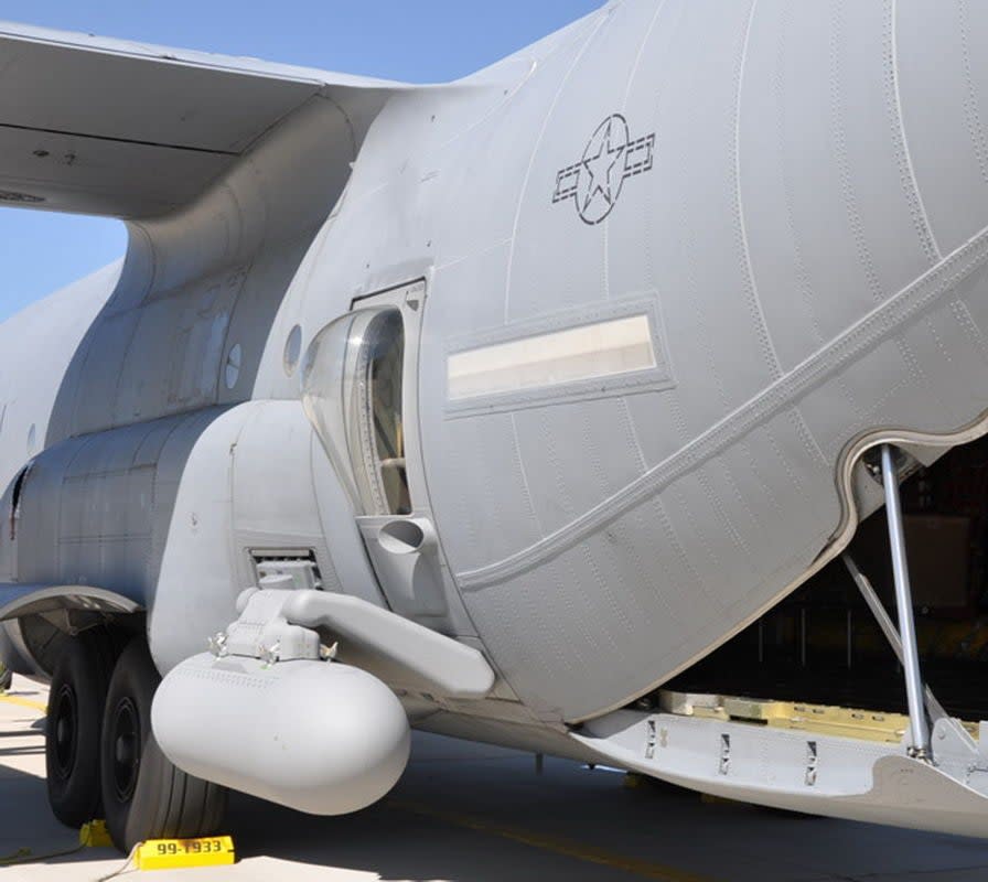 An example of a modified C-130 rear paratrooper door with an add-on pylon with a pod attached. <em>via ThinkDefence.co.uk</em>