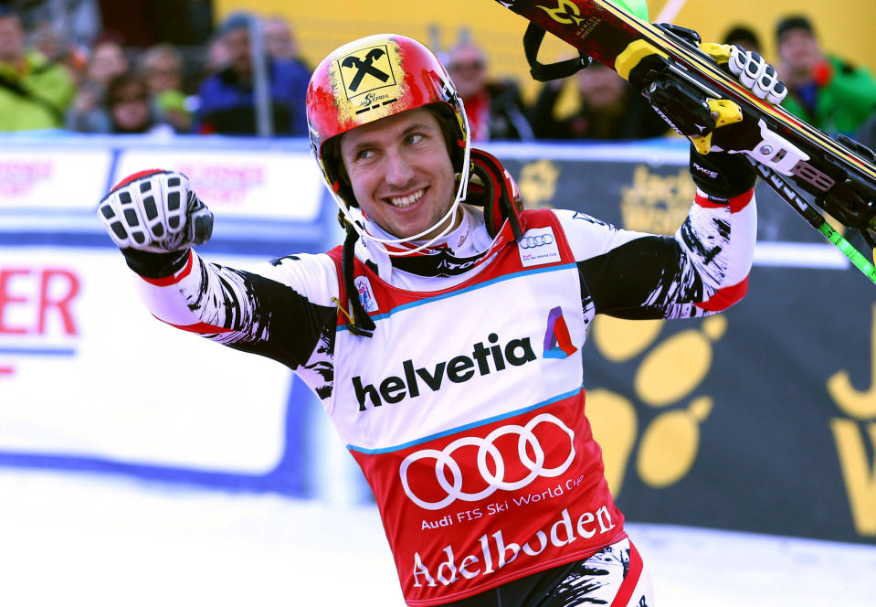 Austria's Marcel Hirscher celebrates at the finish area after winning an alpine ski World Cup men's slalom, looks up from on the podium in Adelboden, Switzerland, Sunday, Jan. 12, 2014. (AP Photo/Giovanni Auletta)