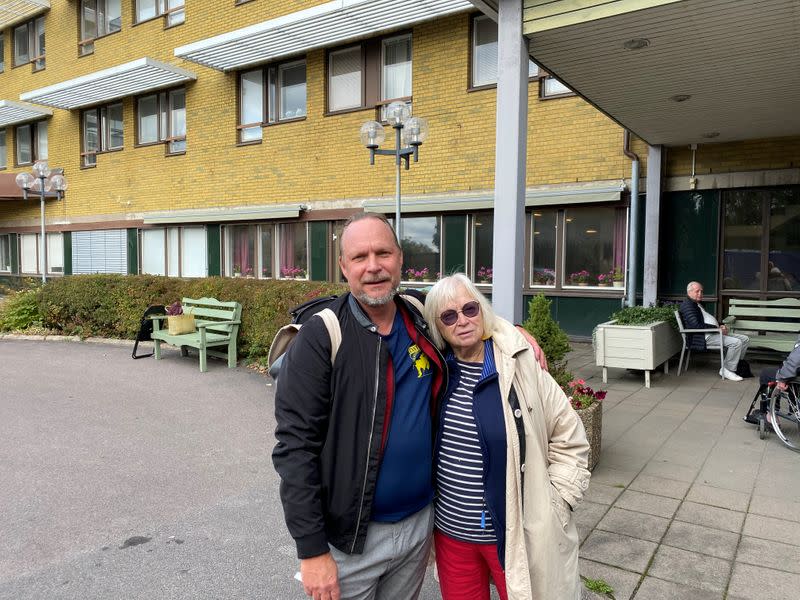 Ingrid Bolander, on her way to visit husband admitted to the care facility, poses with her son Pelle Bolander, in Gothenburg