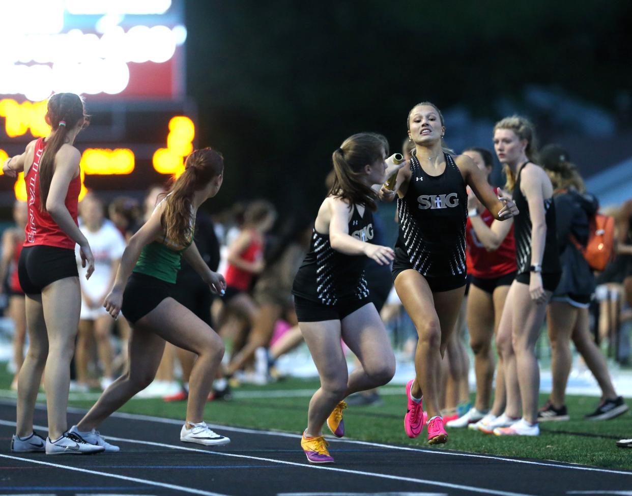 Sacred Heart-Griffin's Macie Rolf passes the baton to Maria Bartletti during the 4x400-meter relay at the Central State Eight Conference girls track and field meet at Memorial Stadium on Thursday, May 2, 2024. Chatham Glenwood won the team title.