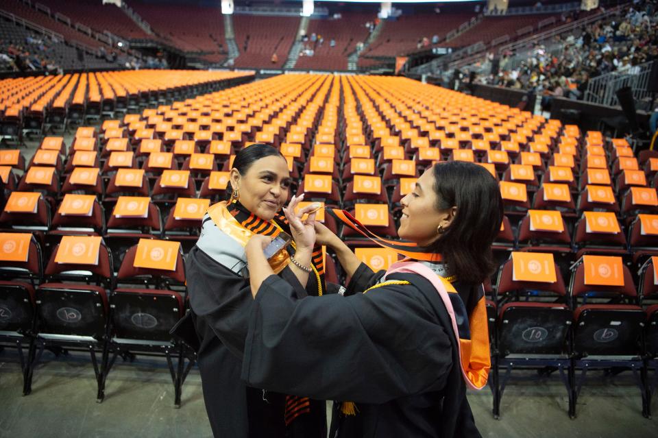 Martínez and her daughter, Janais, prep for the ceremony on the arena floor.