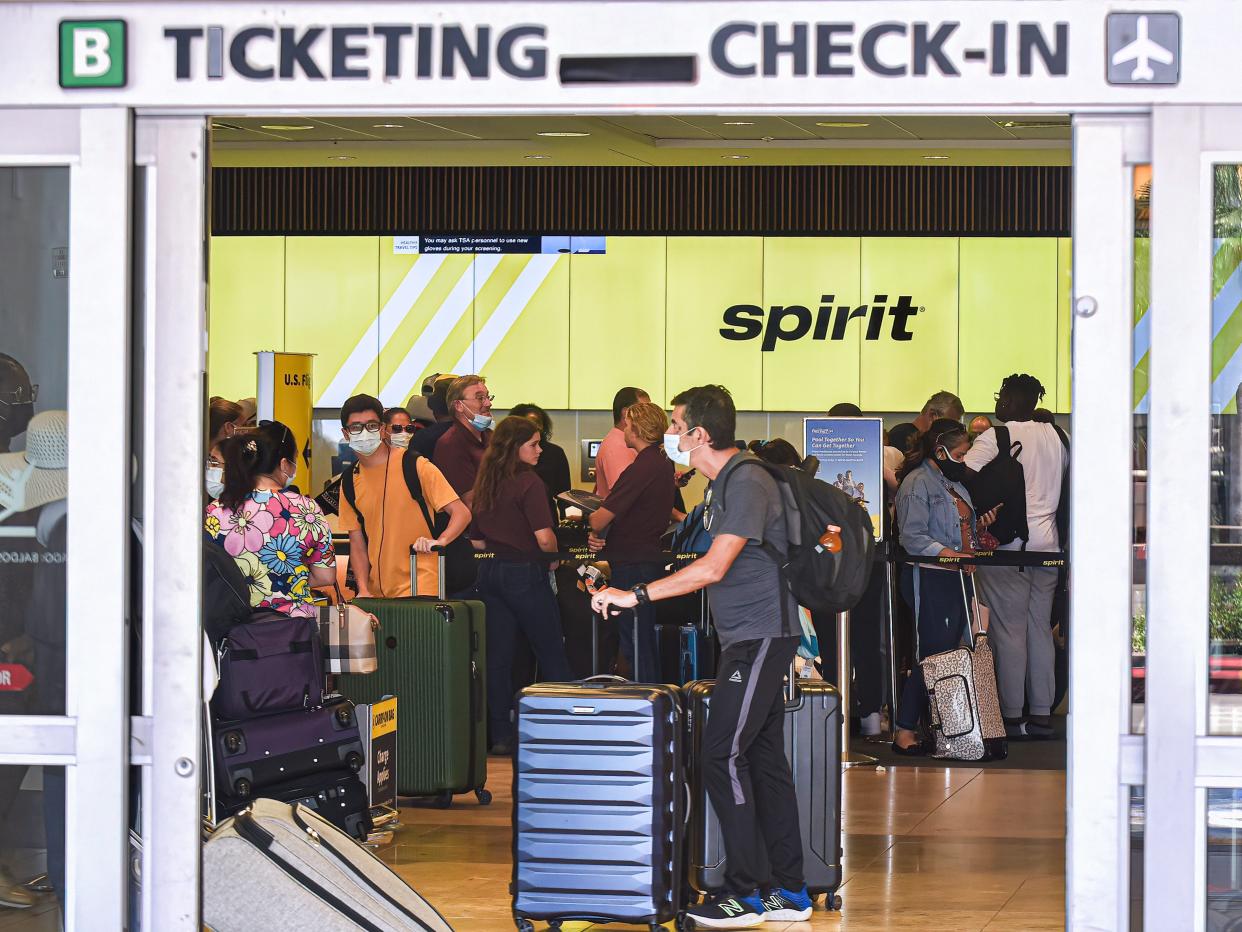 Passengers wait in line at the Spirit Airlines check-in counter at Orlando International Airport on the sixth day the airline has cancelled hundreds of flights.