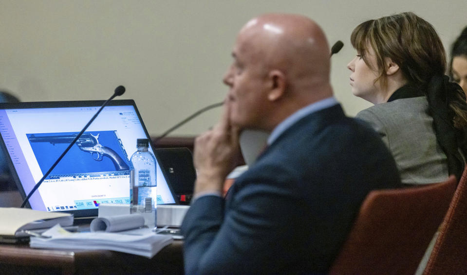 Defendant Hannah Gutierrez-Reed, right, armorer on the set of the movie "Rust', listens as FBI forensic examiner Bryce Ziegler testifies in her trial at District Court , Monday, Feb. 26, 2024, in Santa Fe, N.M. Gutierrez-Reed is charged with involuntary manslaughter and tampering with evidence in the October 2021 death of cinematographer Halyna Hutchins during the filming of the Western. (Luis Sánchez Saturno/Santa Fe New Mexican via AP, Pool)