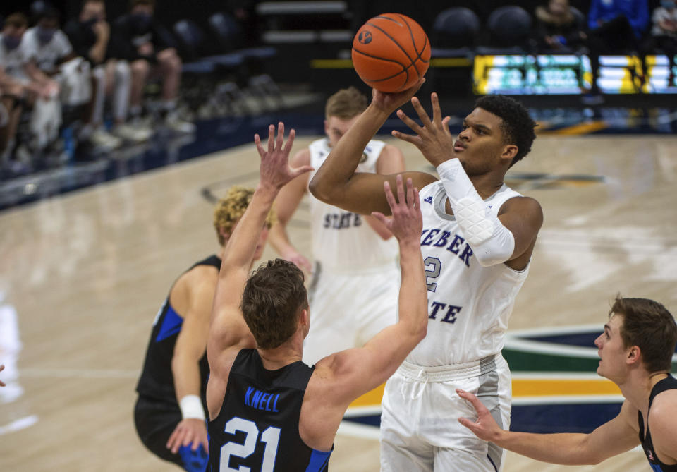 Weber State forward Dillon Jones (2) shoots as Brigham Young guard Trevin Knell (21) defends during an NCAA college basketball game at Vivint Arena in Salt Lake City, Dec. 23, 2020. Weber State’s Dillon Jones and UNC Asheville’s Drew Pember had every reason to decide they’d done enough at this level. Yet both returned to school in part because they wanted their college careers to have a better finish.(Rick Egan/The Salt Lake Tribune via AP)