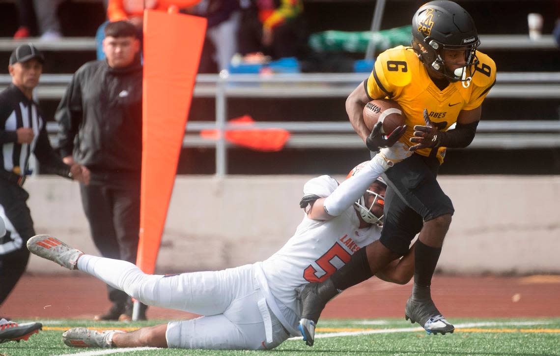 Lincoln wide receiver John John Nelson drags Lakes defensive back Chayanne Fonoti-Savea to the end zone for a touchdown reception during Saturday afternoon’s football game at Lincoln Bowl in Tacoma, Washington, on Oct. 22, 2022.