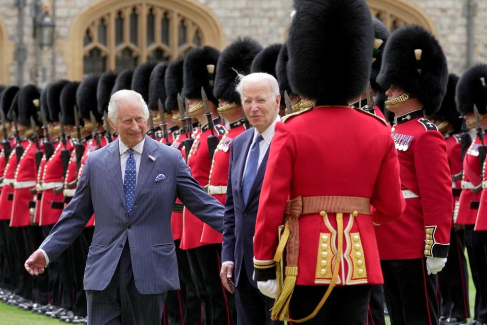 King Charles appears keen to lead President Biden away while the US leader chatted with a guardsman (via REUTERS)