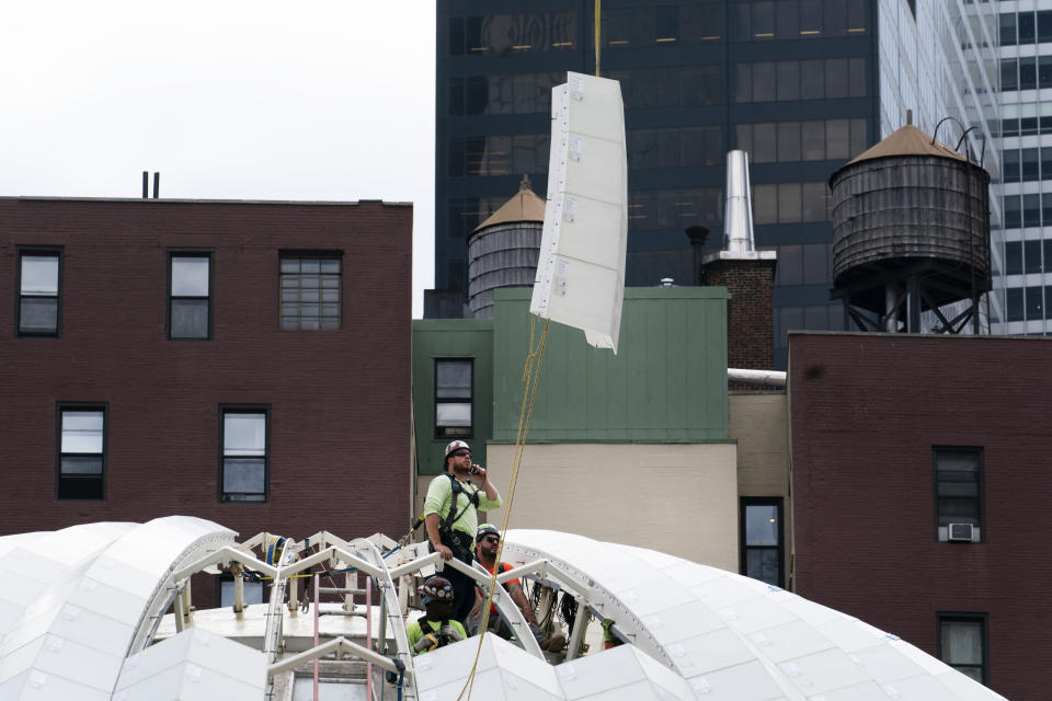 A worker guides a marble roof panel into place at the St. Nicholas Greek Orthodox Church, Wednesday, Sept. 8, 2021, at the World Trade Center in New York. The construction of the only house of worship destroyed in the attacks of September 11, 2001, is now proceeding briskly after years of delays. (AP Photo/Mark Lennihan)