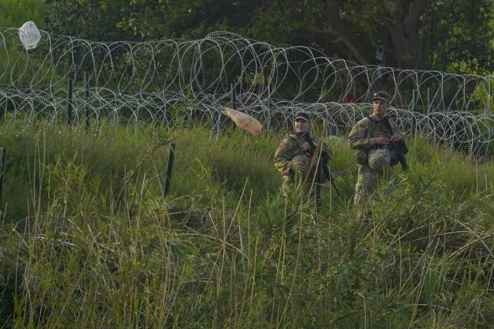 Dos integrantes de la Guardia Nacional de Texas vigilan en la margen estadounidense del río Bravo el jueves 11 de mayo de 2023, en esta fotografía captada desde Matamoros, México. Las restricciones estadounidenses al asilo, implementadas por la pandemia de COVID-19 y conocidas como Título 42, expiraron el 11 de mayo. (AP Foto/Fernando Llano)