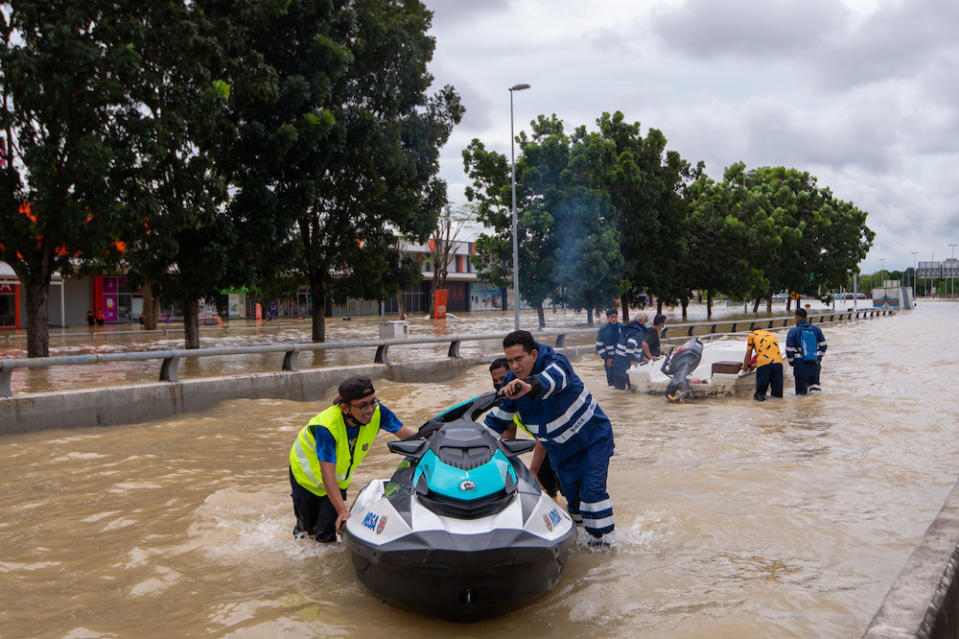 People use water scooters to rescue people after persistent rainfall caused massive floods in Shah Alam, December 18, 2021. ― Picture by Shafwan Zaidon