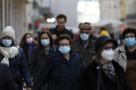 People wearing face masks to curb the spread of COVID-19 walk in downtown Lisbon, Monday, Nov. 29, 2021. Portuguese health authorities on Monday identified 13 cases of omicron, the new coronavirus variant spreading fast globally, among members of the Lisbon-based Belenenses SAD soccer club, and were investigating possible local transmission of the virus outside of southern Africa. (AP Photo/Ana Brigida)