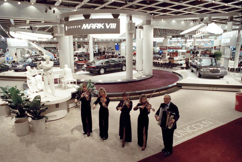 FILE - In this Jan. 5, 1993, file photo, Eddie de Santis and the Singing Strings perform during the Detroit Auto Dealer's Association preview party at the North American International Auto Show in Detroit, Jan. 5, 1993. In 2014, at least 50 new vehicles will make their debut. (AP Photo/Lennox McLendon, FIle)