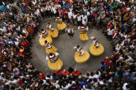 <p>People surround dancers as they perform on stilts in honor of Saint Mary Magdalene in a street for the traditional “Danza de Los Zancos” (Los Zancos Dance), in the small town of Anguiano, northern Spain, July 23, 2016. (AP Photo/Alvaro Barrientos)</p>