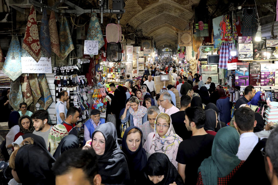 People shop at the old main bazaar in Tehran, Iran, Tuesday, July 2, 2019. From an English-language teacher hoping for peace to an appliance salesman who applauded Donald Trump as a “successful businessman,” all said they suffered from the economic hardships sparked by re-imposed and newly created American sanctions. (AP Photo/Ebrahim Noroozi)