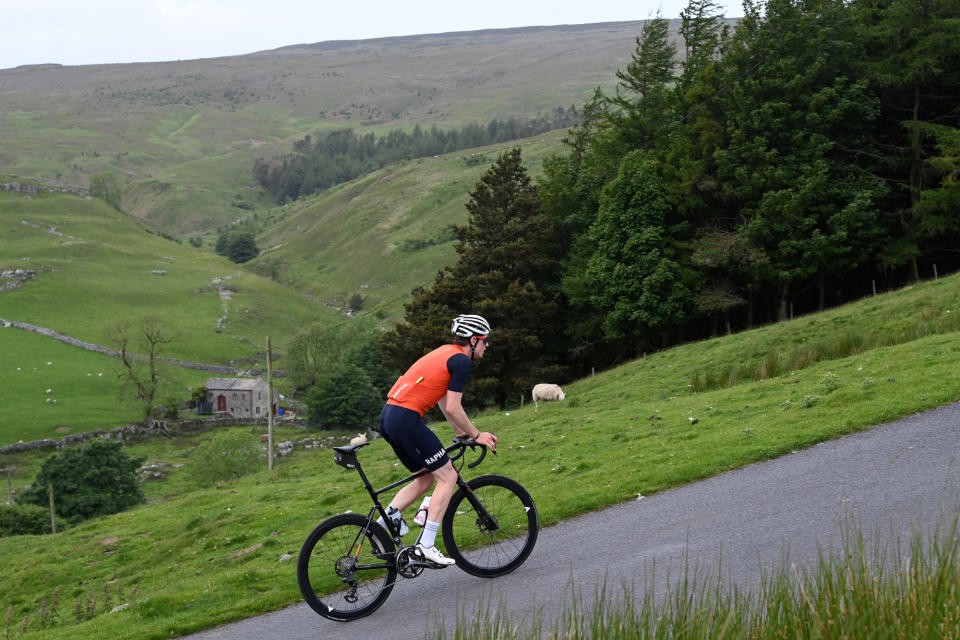Male cyclist riding up a hill