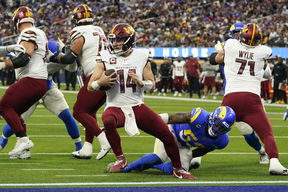 Washington Commanders quarterback Sam Howell (14) is threatened by Los Angeles Rams linebacker Ernest Jones (53) during the second half of an NFL football game Sunday, Dec. 17, 2023, in Inglewood, Calif. (AP Photo/Marcio Jose Sanchez)