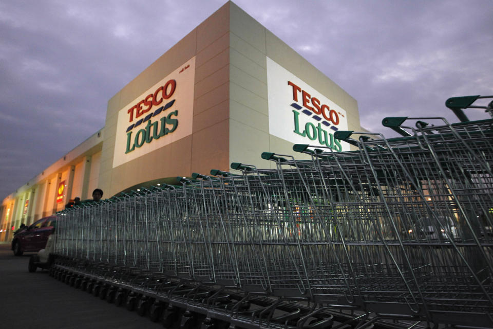 A worker pushes trolleys at a Tesco Lotus supermarket in Bangkok January 12, 2012. Tesco issued its first profit warning in living memory on Thursday, sending shares in British grocers tumbling on fears the world's third-biggest retailer would launch a price war to fight back from its worst Christmas in decades.  REUTERS/Sukree Sukplang (THAILAND - Tags: BUSINESS EMPLOYMENT)