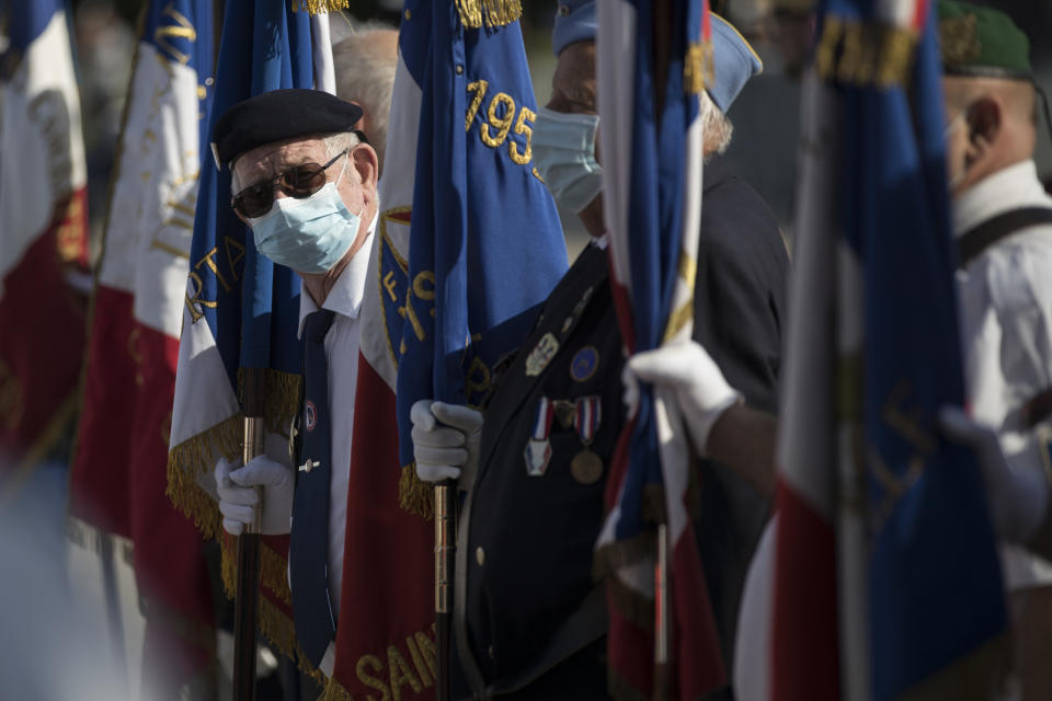 A veteran wears a face mask prior to a Bastille Day ceremony at Parc Borely, Tuesday, July 14, 2020 in Marseille, southern France. France is honoring nurses, ambulance drivers, supermarket cashiers and others on its biggest national holiday Tuesday. Bastille Day's usual grandiose military parade in Paris is being redesigned this year to celebrate heroes of the coronavirus pandemic. (AP Photo/Daniel Cole)