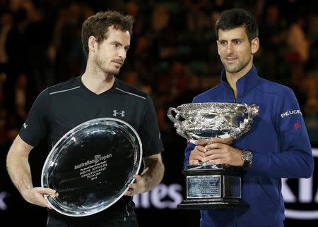 Serbia's Novak Djokovic (R) stands with the men's singles trophy beside Britain's Andy Murray after winning their final match at the Australian Open tennis tournament at Melbourne Park, Australia, January 31, 2016. REUTERS/Tyrone Siu