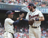 Atlanta Braves' Ozzie Albies, left, and Dansby Swanson celebrate after turning a double play against the Pittsburgh Pirates on a bunt during the second inning of a baseball game Sunday, May 23, 2021, in Atlanta. (Curtis Compton/Atlanta Journal-Constitution via AP)