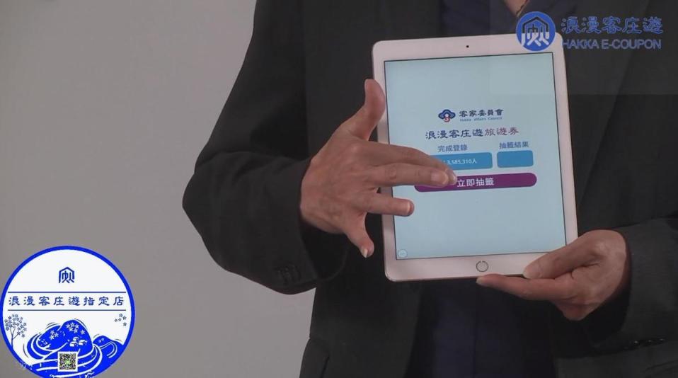 客委會副主委鍾孔炤在iPad上點選一鍵抽籤，電腦就自動「亂數」抽出14萬份中獎名單。（翻攝自客家委員會臉書粉專）