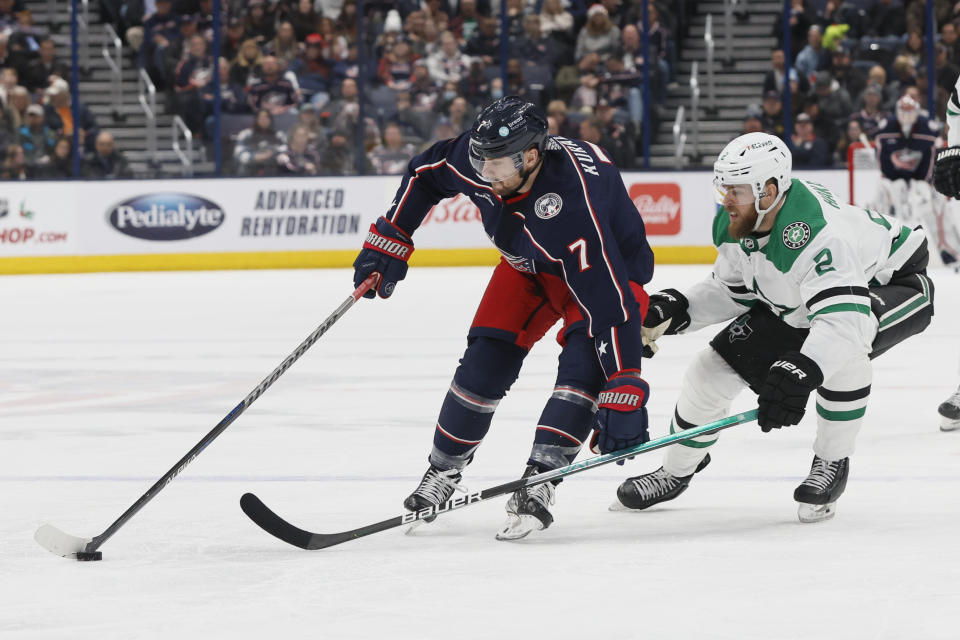 Columbus Blue Jackets' Sean Kuraly, left, moves the puck across the blue line past Dallas Stars' Jani Hakanpaa during the second period of an NHL hockey game on Monday, Dec. 19, 2022, in Columbus, Ohio. (AP Photo/Jay LaPrete)