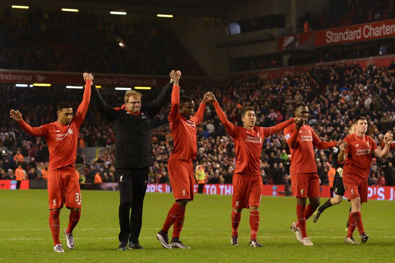 Liverpool's German manager Jürgen Klopp (2nd left) leads his players in saluting the crowd, together with (left to right) Liverpool's English midfielder Jordan Ibe, Liverpool's Belgian striker Divock Origi, Liverpool's Brazilian midfielder Roberto Firmino, Liverpool's Zairean-born Belgian striker Christian Benteke and Liverpool's English midfielder James Milner after the draw during the English Premier League soccer match between Liverpool and West Bromwich Albion at Anfield in Liverpool, northwest England, on 13 December 2015. Liverpool drew 2-2 with West Brom.
