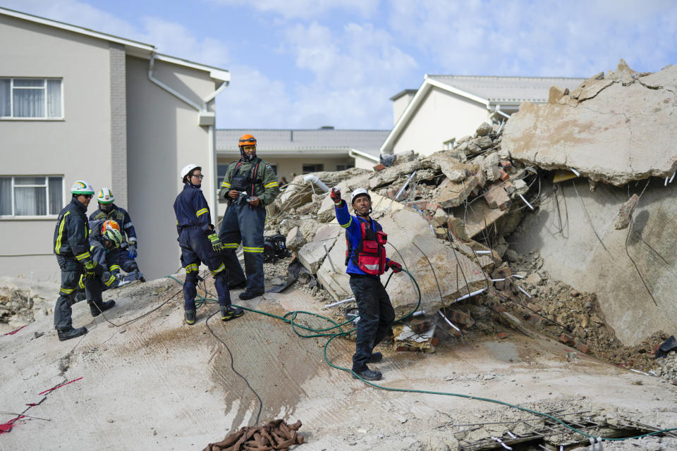 Rescue workers search the site of a building collapse in George, South Africa, Wednesday, May 8, 2024. Rescue teams are searching for dozens of construction workers missing after a multi-story apartment complex collapsed in the coastal city have brought out more survivors as the operation entered a second night of desperate work to find anyone alive in the mangled wreckage. (AP Photo/Jerome Delay)